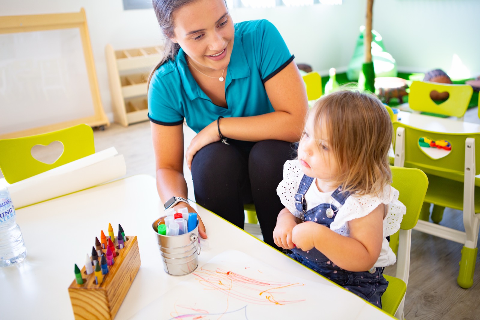 An educator working one to one with a child at a low table